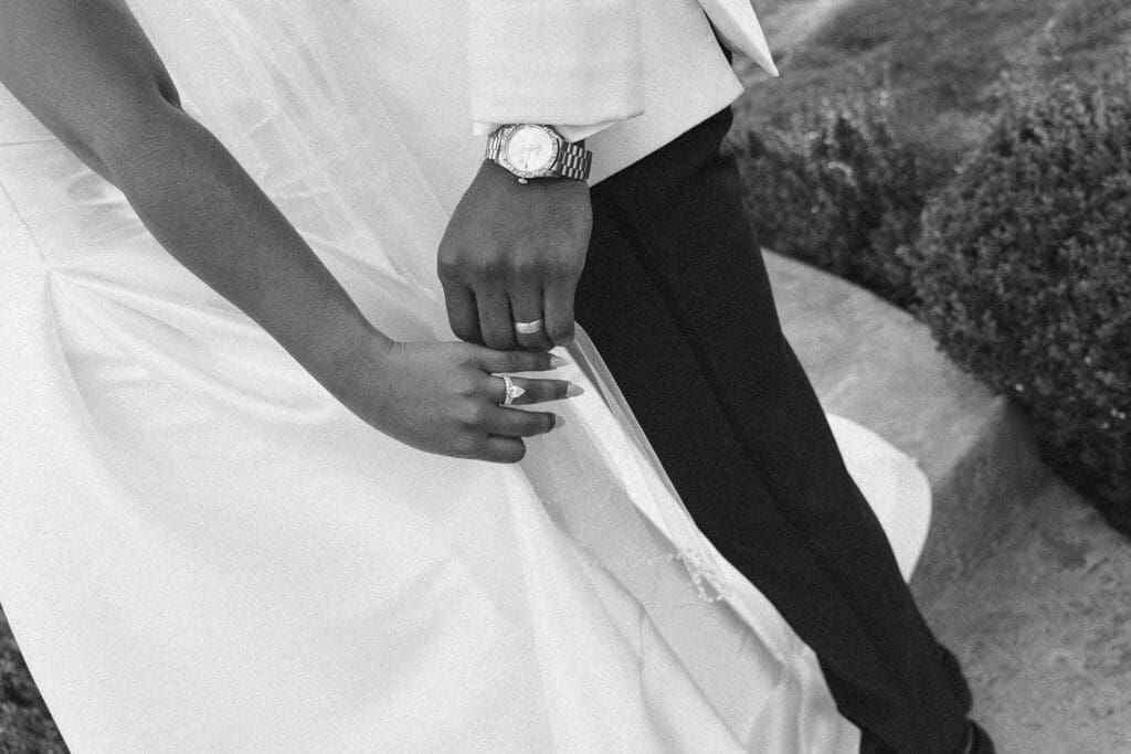 Close-up of bride and groom holding hands with wedding rings