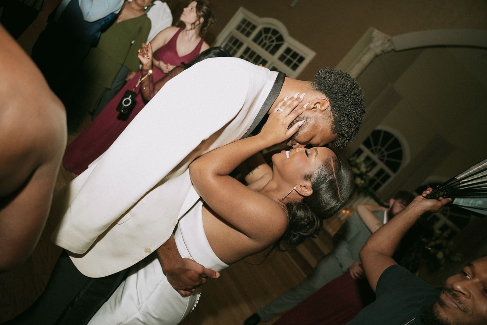 Couple kissing while guests celebrate at Morais Vineyards wedding