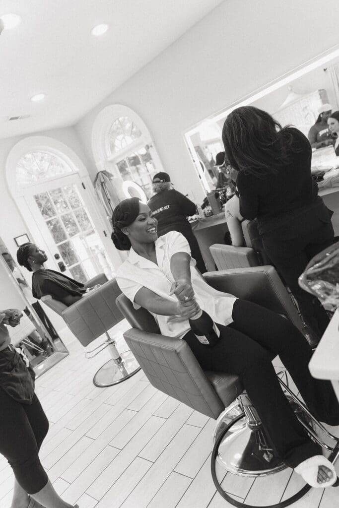 Bride laughing while getting hair and makeup done before wedding ceremony