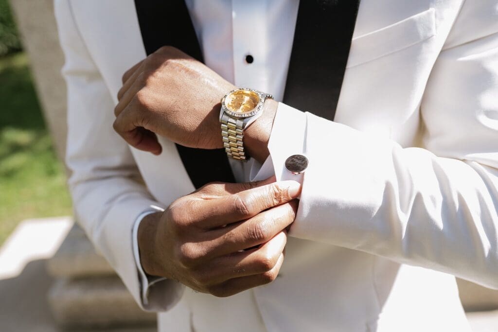 Groom adjusting cufflinks and watch before Morais Vineyards & Winery wedding