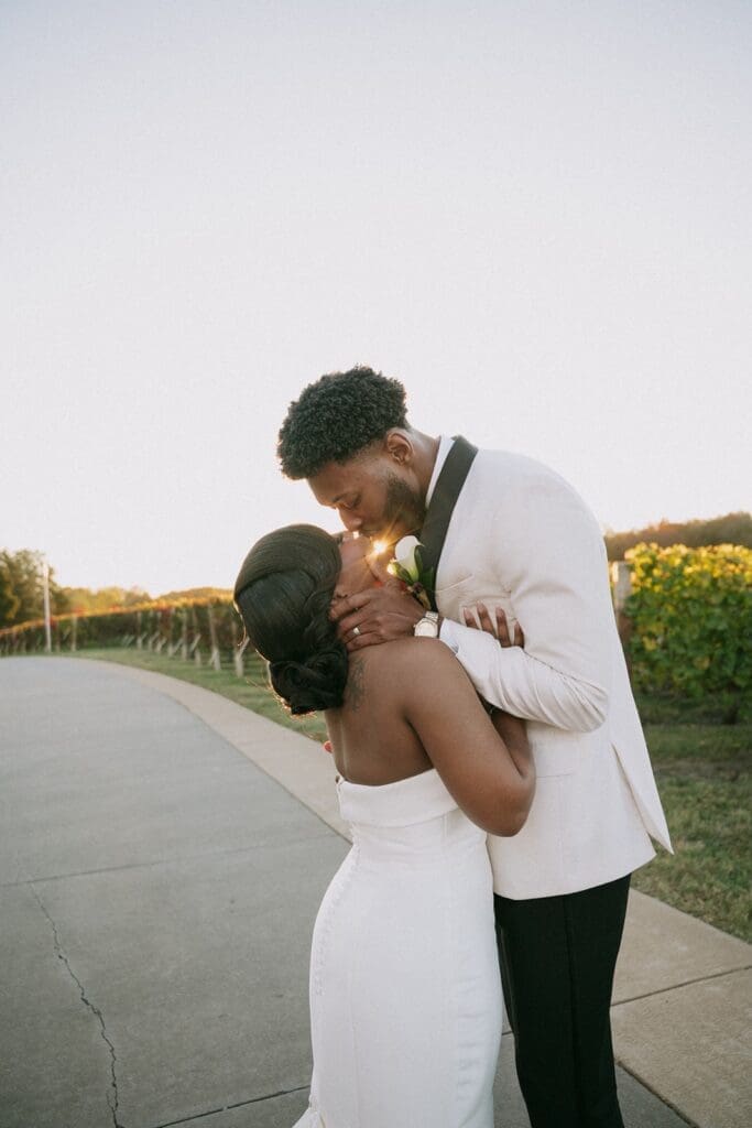 Bride and groom kissing at sunset in the Morais Vineyards vineyard