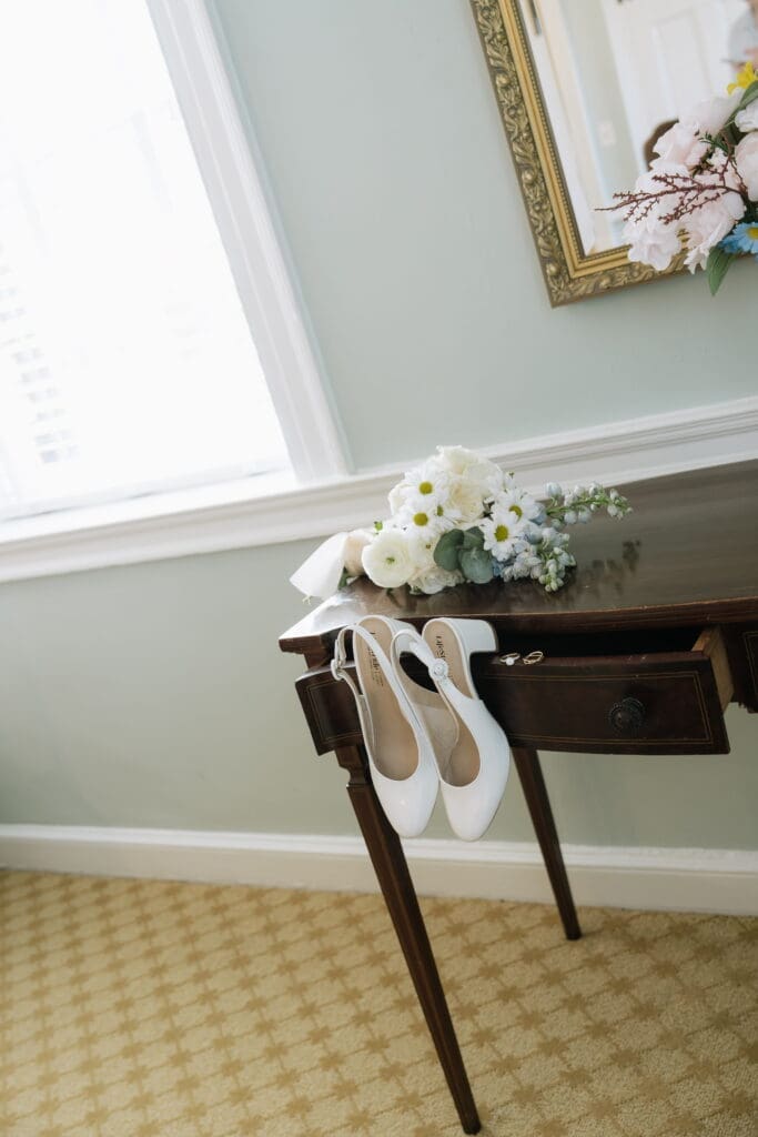 Wedding detail photo of bridal shoes, rings and flowers