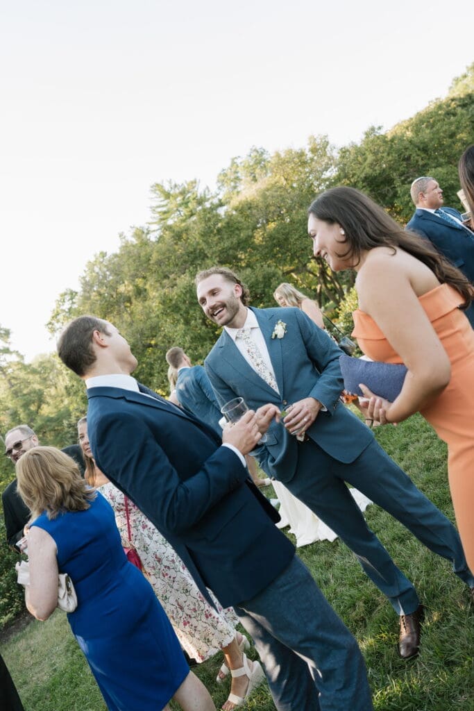 Groom laughing with guests during cocktail hour