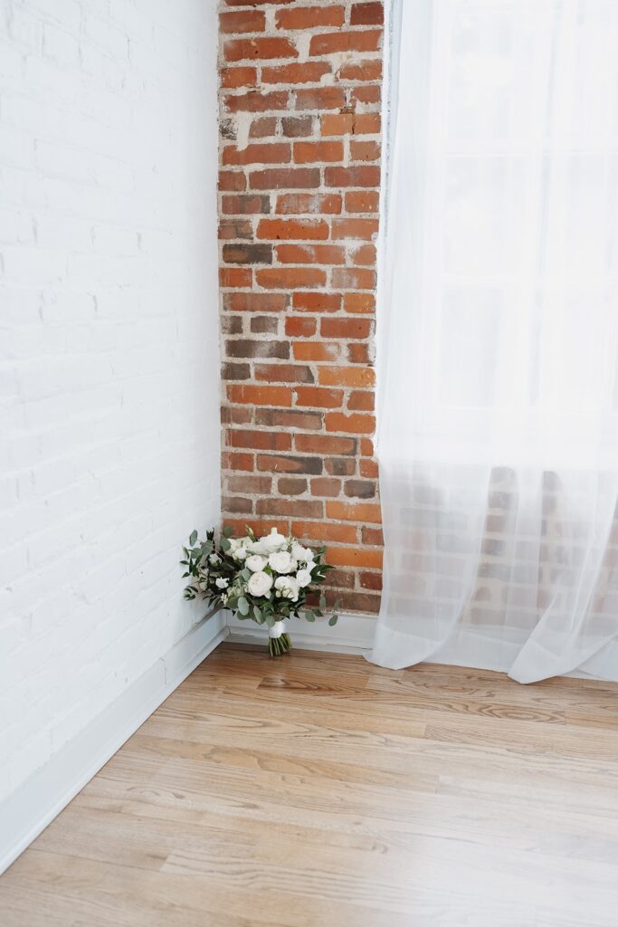 White bridal bouquet with greenery at The Woolen Mill wedding.