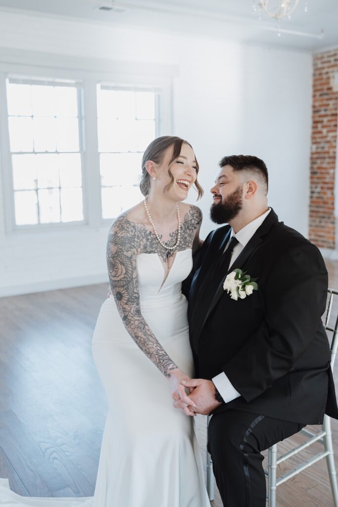 Bride and groom laughing together during their wedding portraits.