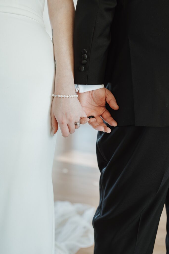 Bride and groom holding hands during portraits at The Woolen Mill.