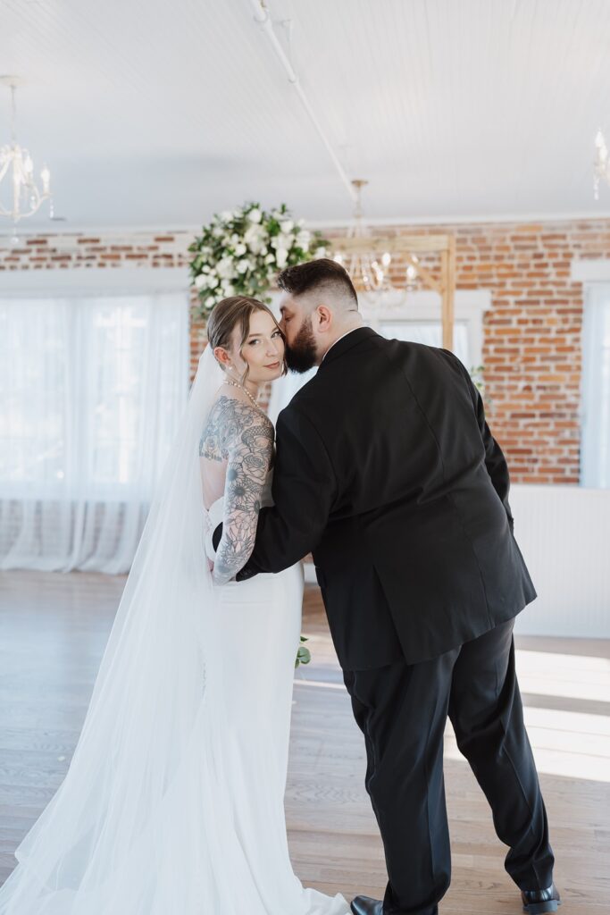 Bride and groom embracing inside The Woolen Mill in Fredericksburg, Virginia.