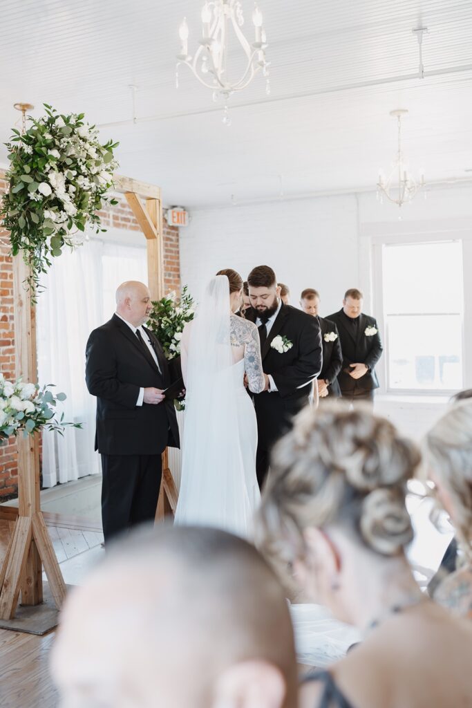 Bride and groom exchanging rings at The Woolen Mill wedding.