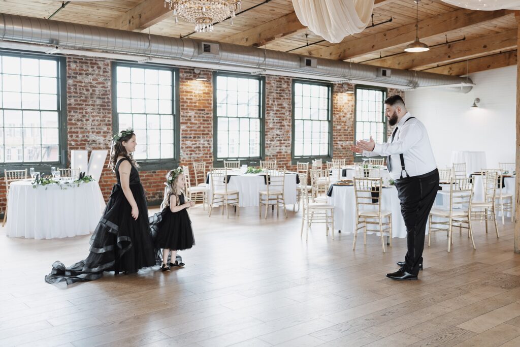 Groom sharing a first look with his daughters before the wedding ceremony at The Woolen Mill.