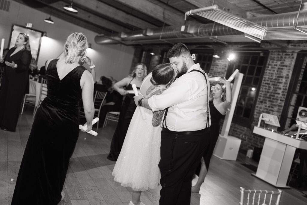 Bride and groom kissing during a wedding reception inside The Woolen Mill in Fredericksburg, Virginia.