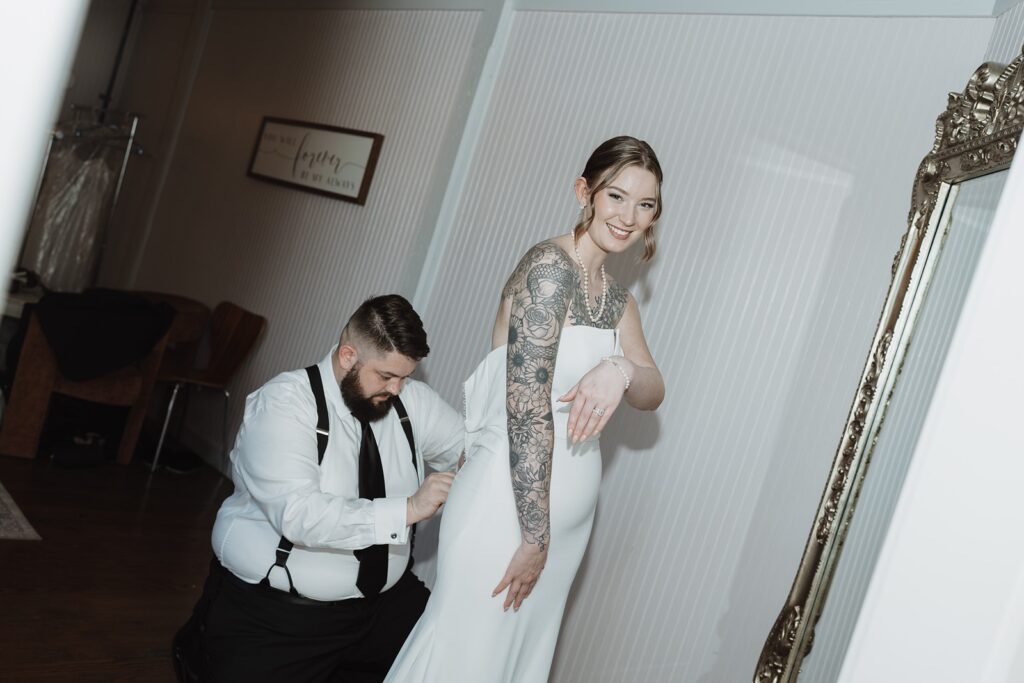 Groom helping with the bride's dress in Fredericksburg, VA.