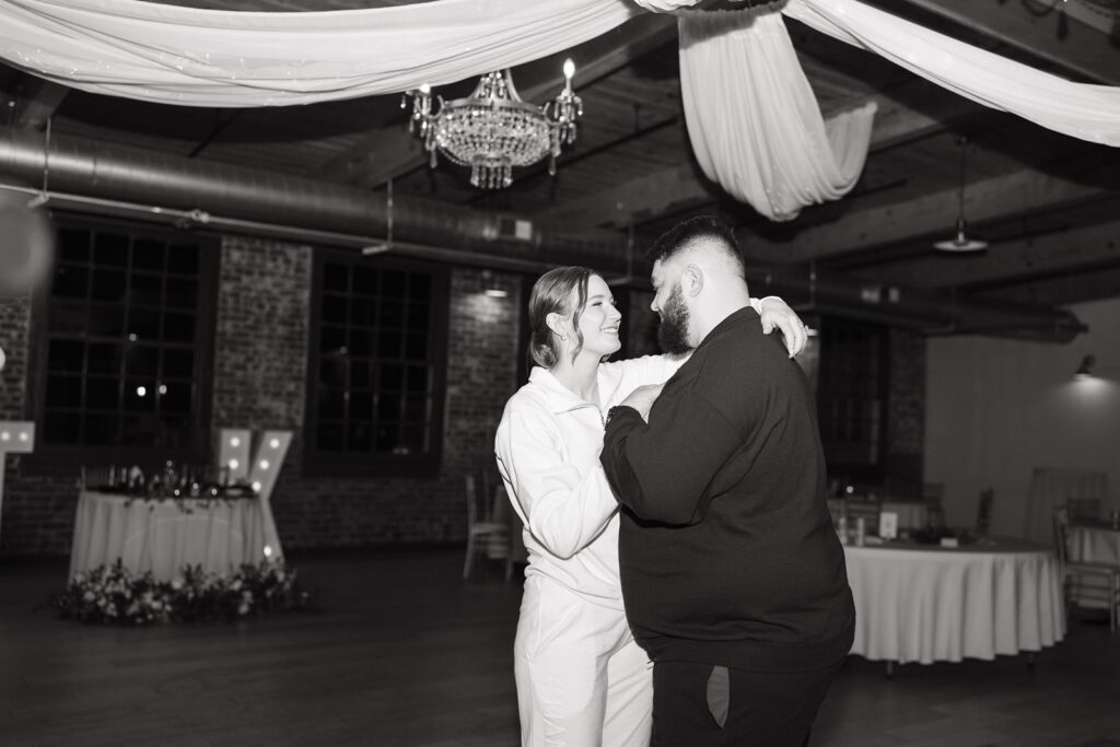 Bride and groom wearing matching sweaters for their private last dance.