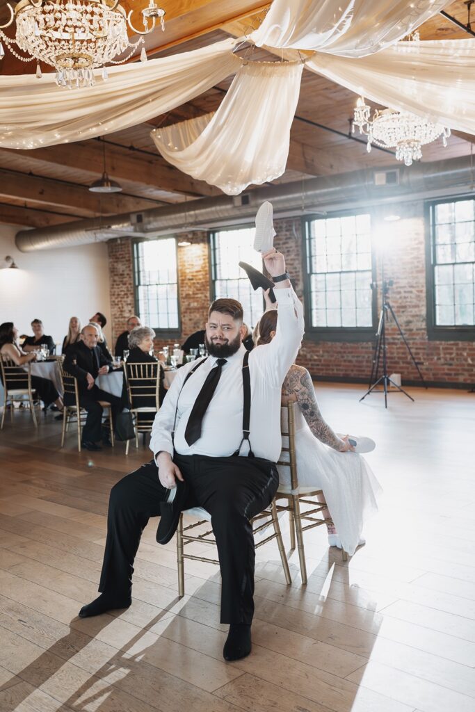 Bride and groom playing the show game during a wedding reception inside The Woolen Mill in Fredericksburg, Virginia.